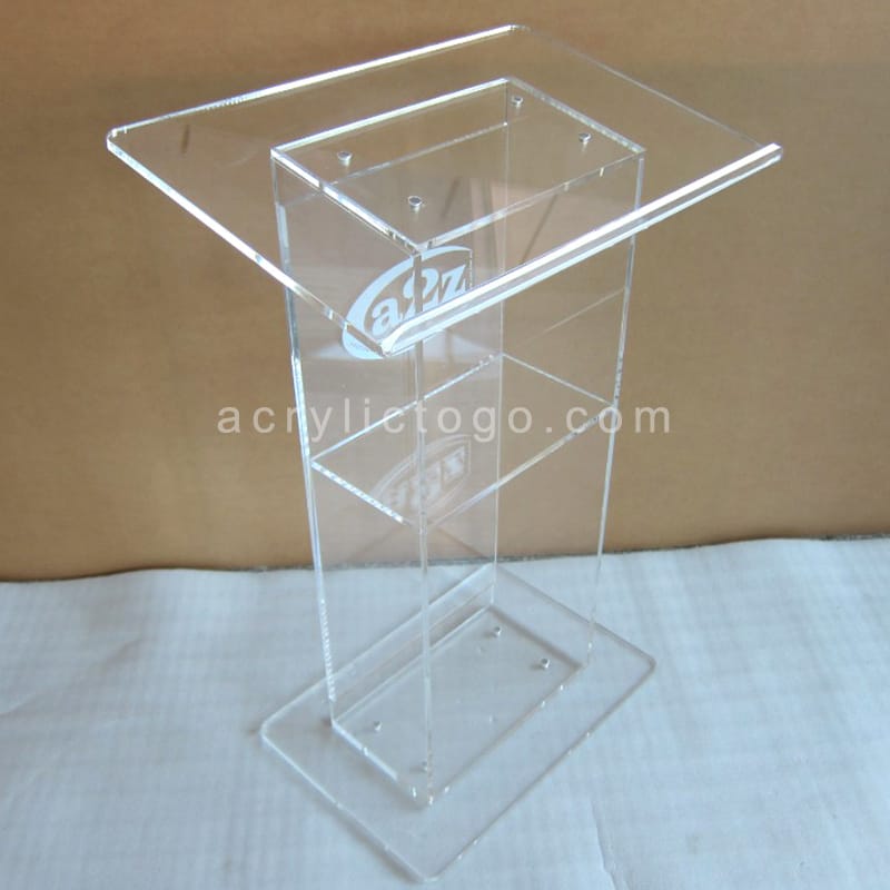 Clear acrylic lectern with laser engraved logo on reading surface, top angle view