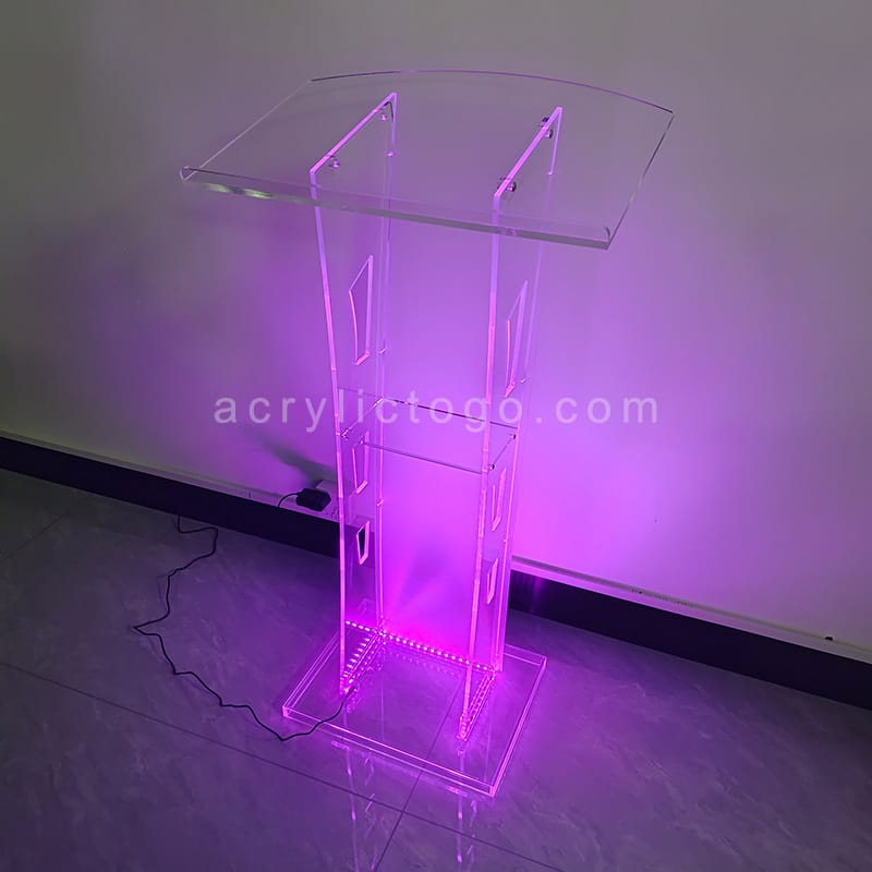 Clear acrylic lectern with RGB LED strip lighting at base casting purple glow
