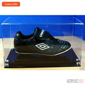 Umbro football boot displayed in custom acrylic display case with black base and stainless metal feet — OEM collectible showcase wholesale manufacturer