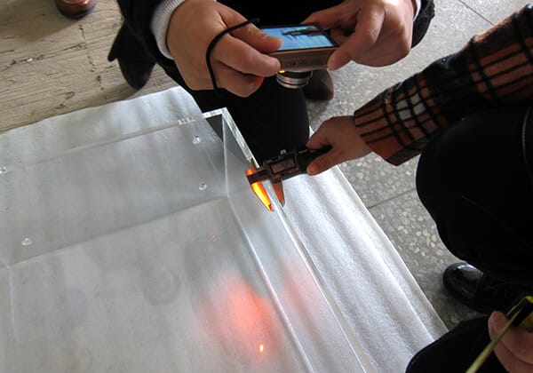 Quality technician measuring acrylic dimensions during production at ACRYLIC2GO