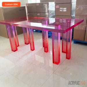 Custom gradient acrylic dining table with pink-to-clear ombre tabletop and nine acrylic legs