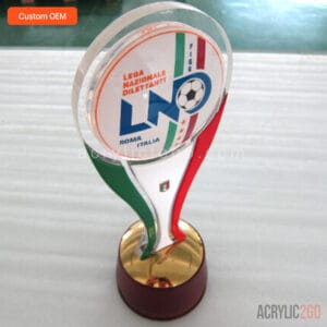 Custom oval acrylic sports trophy with a thick acrylic disc and domed lens pieces on both sides, 4-color printed with raised lettering, foil-laminated painted ribbon stem, and wood base with a gold-electroplated metal cap