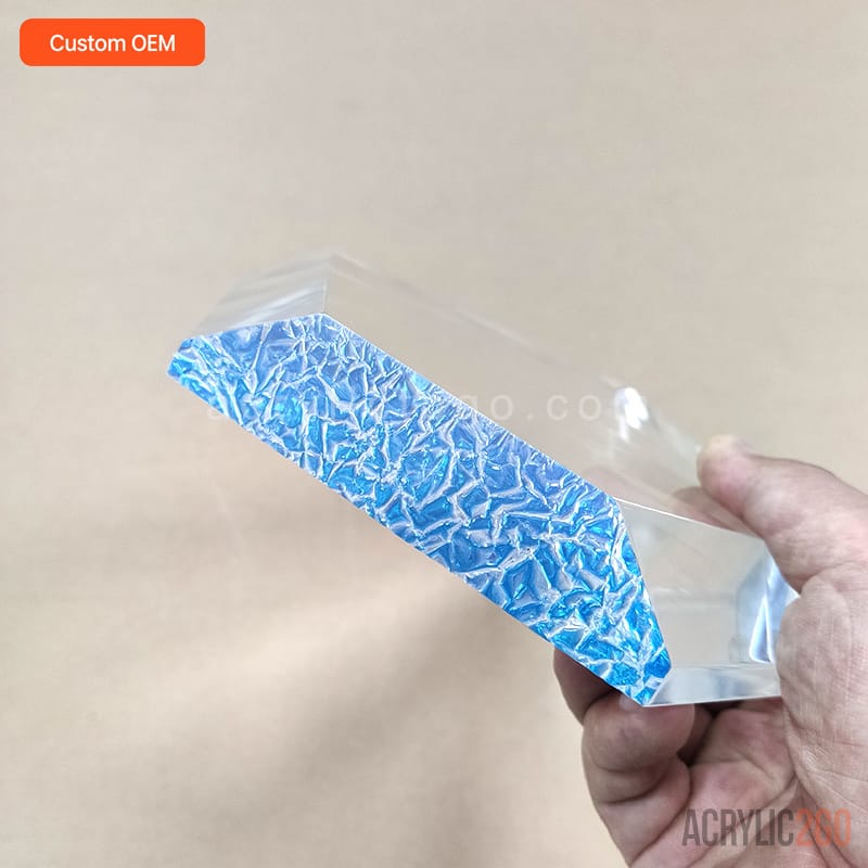 Close-up of the blue ice-crackle textured base on a faceted crystal acrylic trophy, held in hand