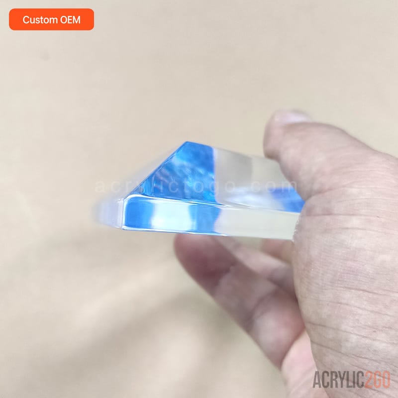 Close-up of a hand-polished beveled facet on a custom acrylic trophy, held in hand