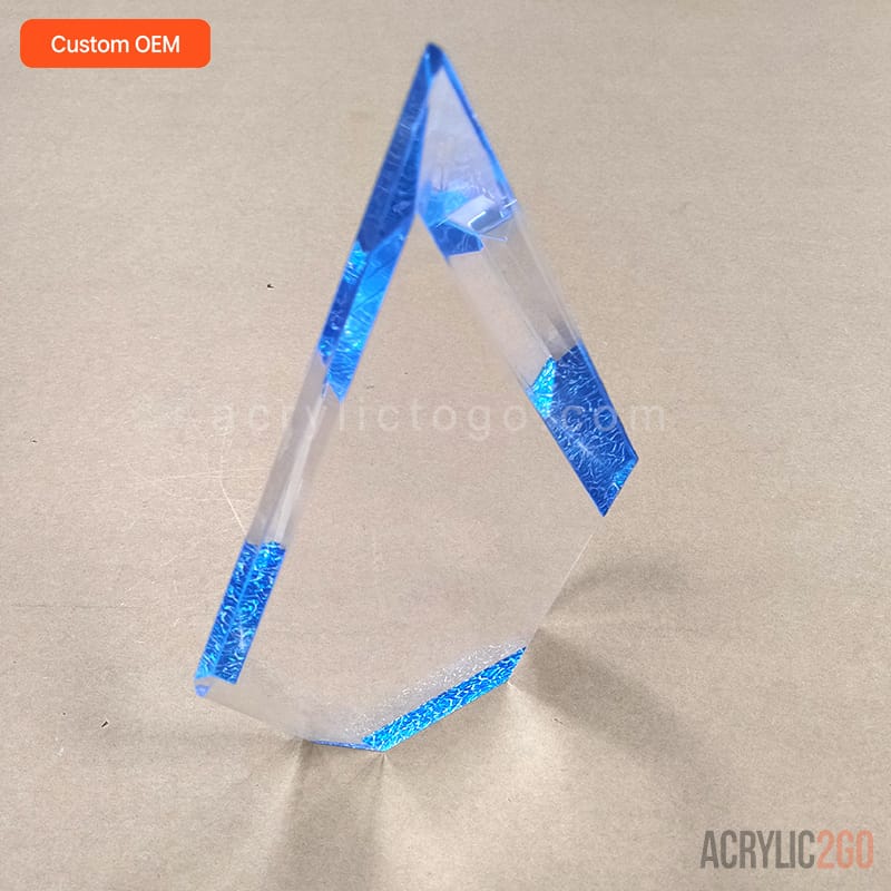 Faceted crystal acrylic trophy viewed from a high angle, showing the pointed tip and faceted top surfaces