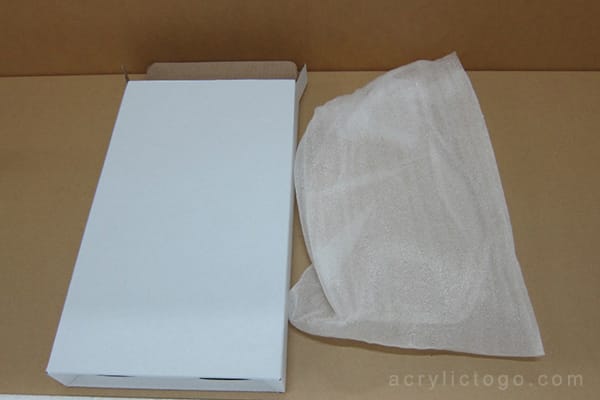 Plain white box and protective mesh wrap used for neutral, unbranded acrylic trophy and award packaging