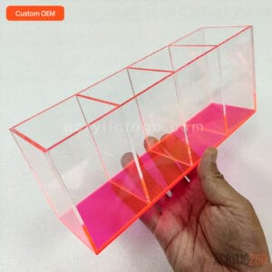 Fluorescent pink acrylic compartment tray with four equal sections, held in hand for scale