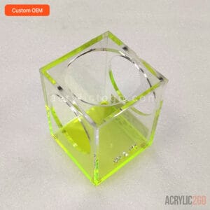 Fluorescent lime acrylic desk tidy with two overlapping circular cutout windows, front angled view
