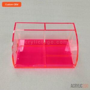 Neon pink multi-compartment acrylic desk caddy with a curved corner, front view