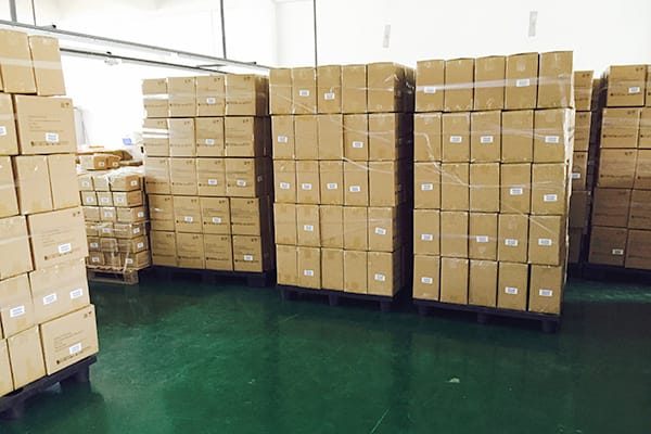 Stacks of shrink-wrapped export cartons palletized in a warehouse ready for shipment