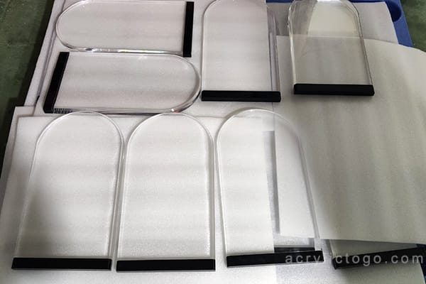 Finished acrylic award plaques with arched tops and polished edges, ready for inspection